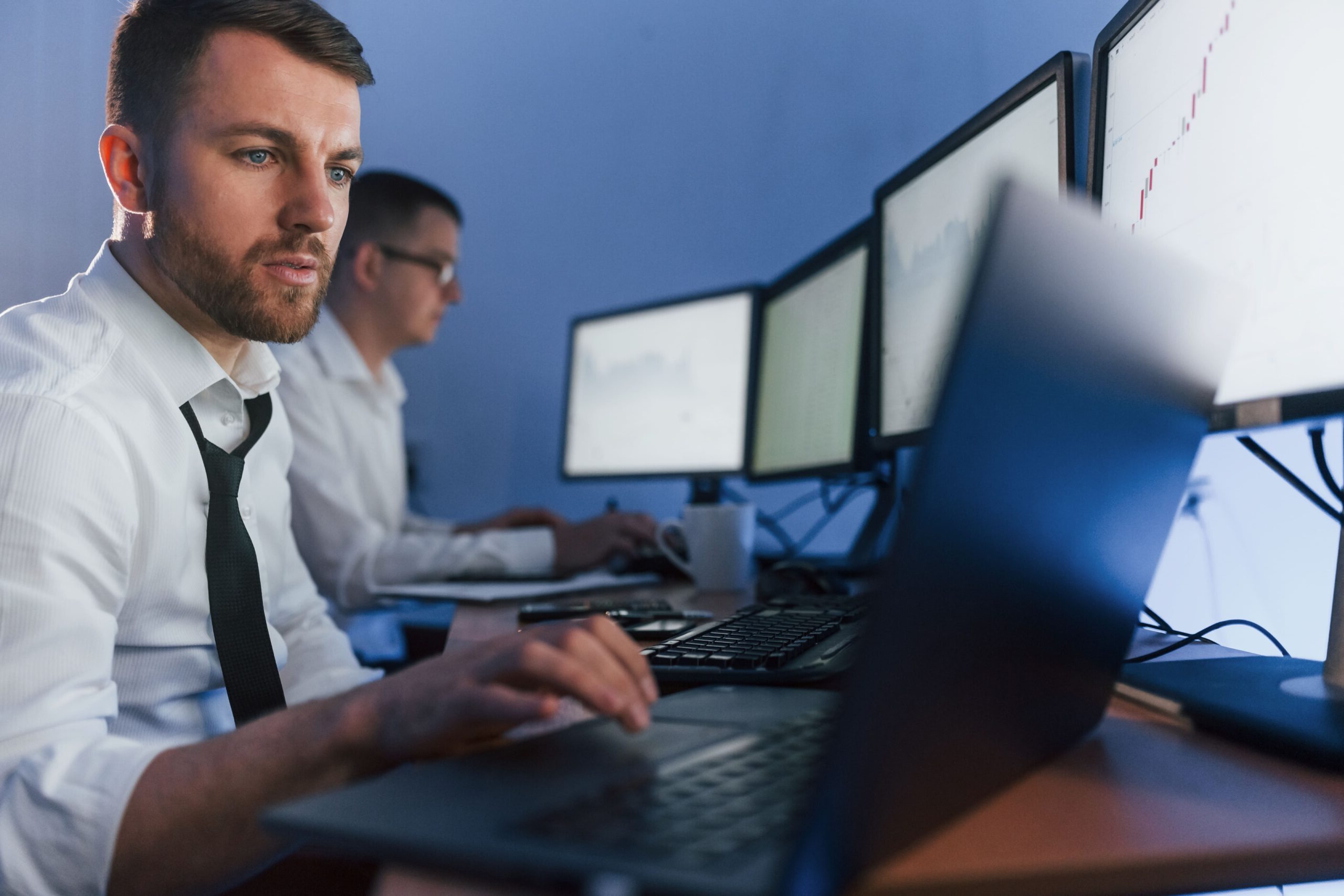 two employees working on laptops